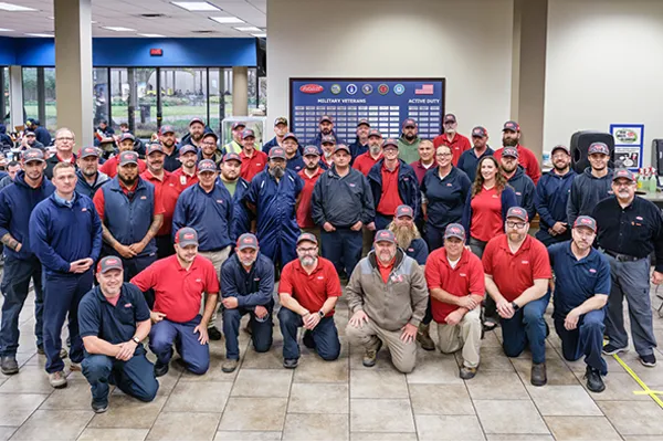 Image of Peterbilt employees in front of the Peterbilt Honor Wall